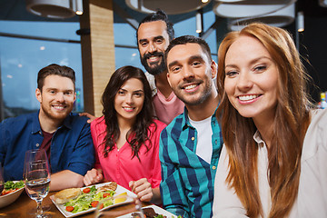 Image showing friends taking selfie by smartphone at restaurant