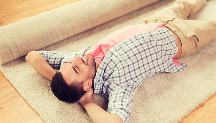 Image showing happy man lying carpet or rug at home