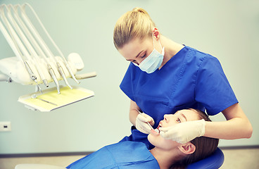 Image showing female dentist checking patient girl teeth