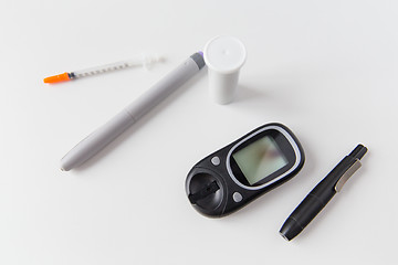 Image showing close up of glucometer, insulin pen and syringe