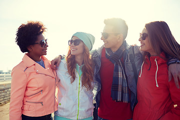 Image showing happy teenage friends in shades talking on street