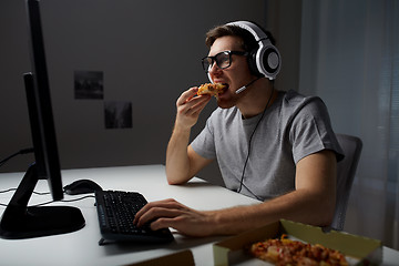 Image showing man in headset playing computer video game at home