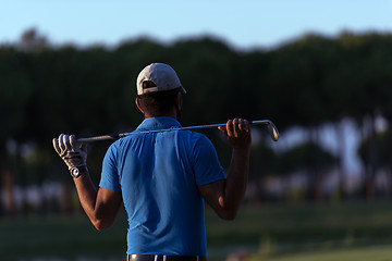 Image showing golfer from back at course looking to hole in distance