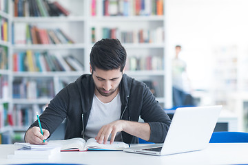 Image showing student in school library using laptop for research