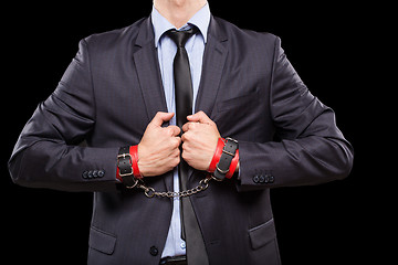 Image showing man in a business suit with leather bound. handcuffs. sex Toys