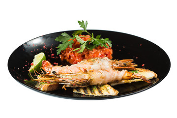 Image showing perfect dish with shrimps on a black plate. seafood. Isolated  white background
