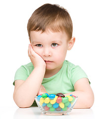 Image showing Portrait of a sad little boy with candies