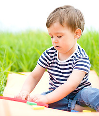 Image showing Little boy is playing with toys