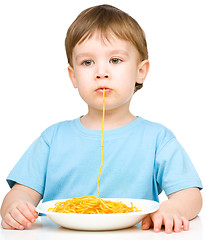 Image showing Little boy is eating spaghetti