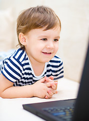 Image showing Little boy is playing on laptop