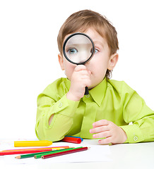 Image showing Cute little boy is playing with magnifier