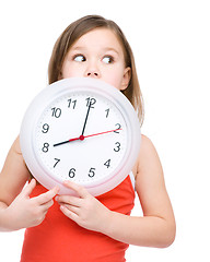 Image showing Little girl is holding big clock