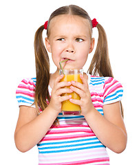 Image showing Little girl unwillingly drinking orange juice