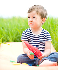 Image showing Little boy is playing with toys