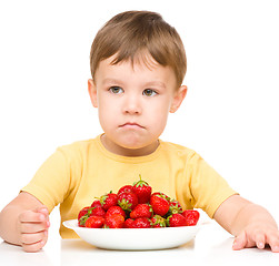 Image showing Little boy refuses to eat strawberries