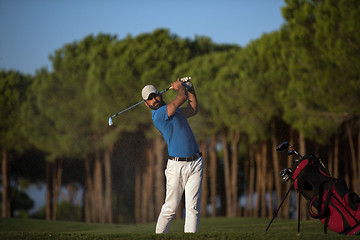 Image showing golfer hitting a sand bunker shot on sunset