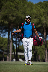 Image showing golf player walking and carrying bag