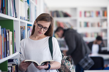 Image showing portrait of famale student reading book in library