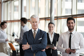 Image showing portrait of senior businessman as leader  with group of people i