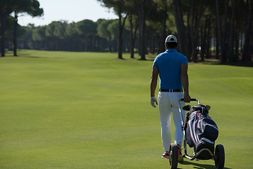 Image showing golf player walking with wheel bag