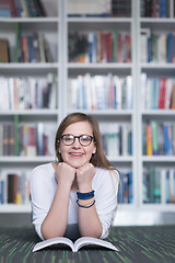 Image showing female student study in library, using tablet and searching for 