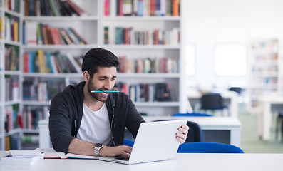 Image showing student in school library using laptop for research