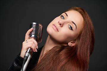 Image showing Closeup of young woman with retro microphone