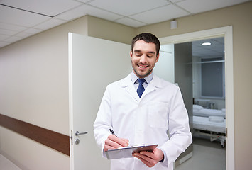 Image showing smiling doctor with clipboard at hospital