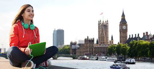 Image showing happy young woman with tablet pc and headphones