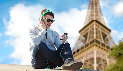 Image showing happy young man in headphones with smartphone