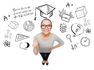 Image showing happy woman showing thumbs up over school doodles