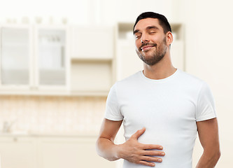 Image showing happy full man touching tummy over kitchen