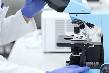 Image showing close up of hands with microscope and blood sample