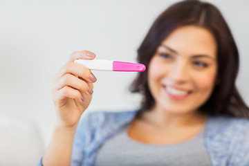 Image showing close up of happy woman with home pregnancy test