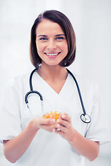 Image showing doctor holding bowl of capsules