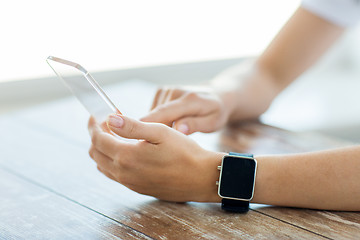 Image showing close up of hands with smart phone and watch