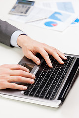 Image showing close up of businessman hands typing on laptop