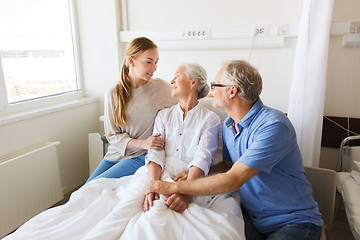 Image showing happy family visiting senior woman at hospital