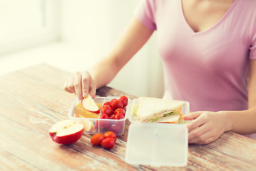 Image showing close up of woman with food in plastic container