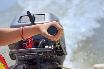 Image showing fisherman hand and boat engine