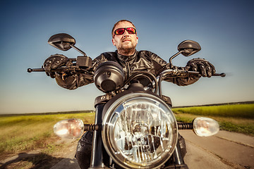 Image showing Biker racing on the road