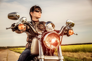 Image showing Biker girl sitting on motorcycle