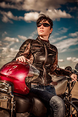 Image showing Biker girl sitting on motorcycle