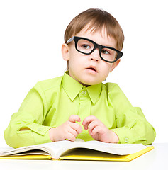 Image showing Little child play with book