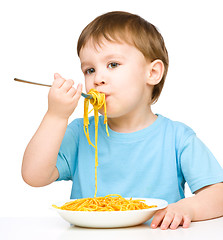 Image showing Little boy is eating spaghetti