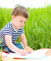 Image showing Little boy is playing with pencils