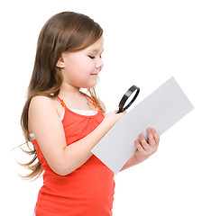 Image showing Girl is looking at big paper using magnifier