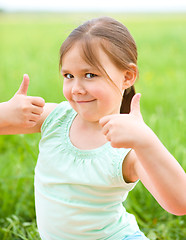 Image showing Little girl is showing thumb up gesture