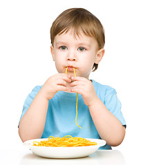 Image showing Little boy is eating spaghetti