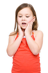 Image showing Little girl is holding her face in astonishment